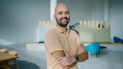 The testimonial, Stefan is shown up to his upper body. He is smiling at the camera and has his arms crossed.