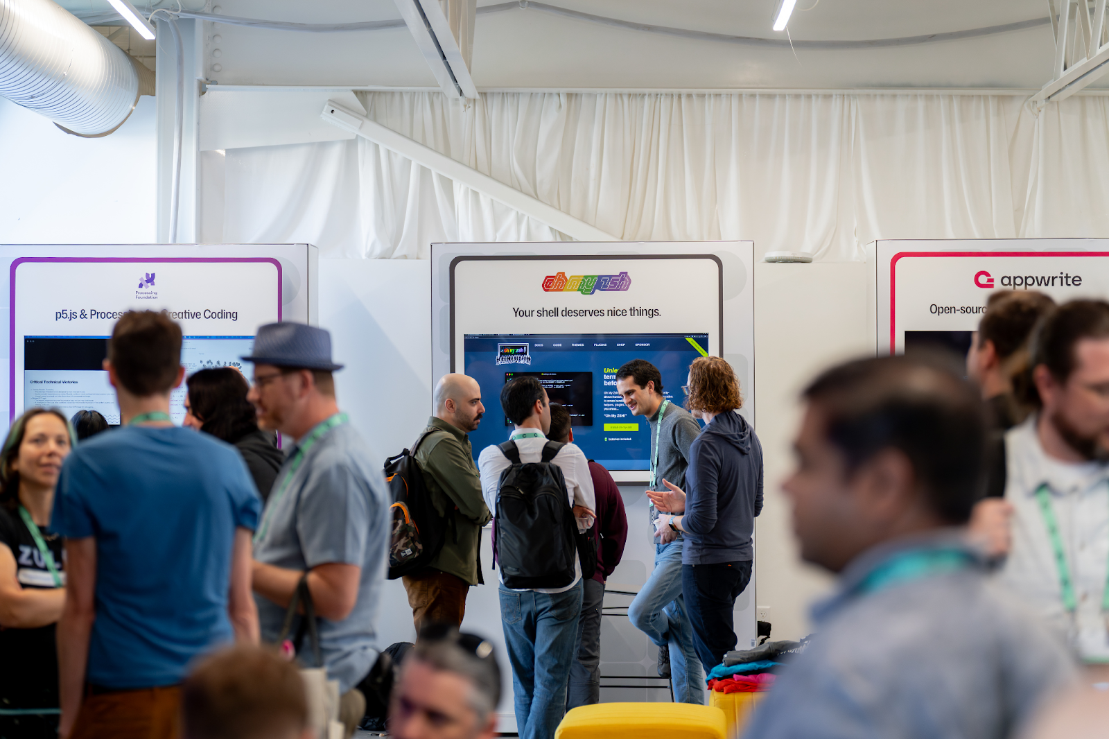 Photo of developers mingling at the Open Source Zone at GitHub Universe 2025.